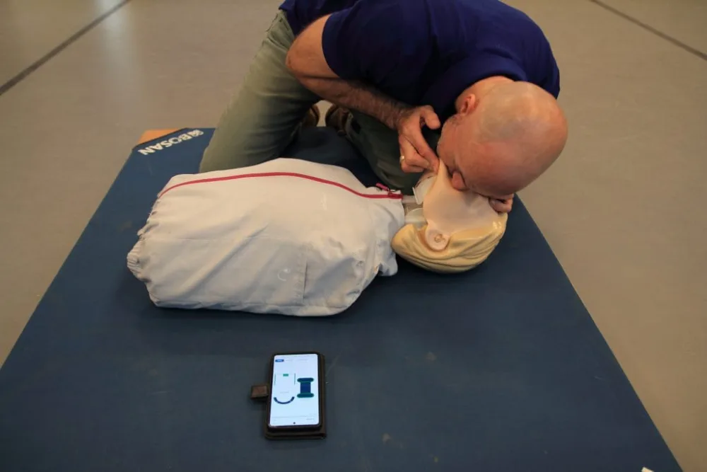 Cursist oefent beademing op een reanimatiepop tijdens de EHBO-training van Whyskills.