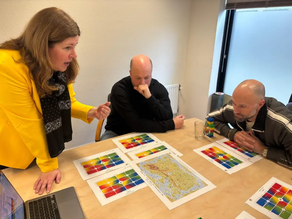 Team in gesprek over de DISC-gedragsstijlen tijdens de training gedrag en communicatie.